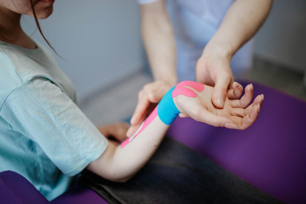 Physiotherapeut behandelt das Handgelenk einer Patientin
